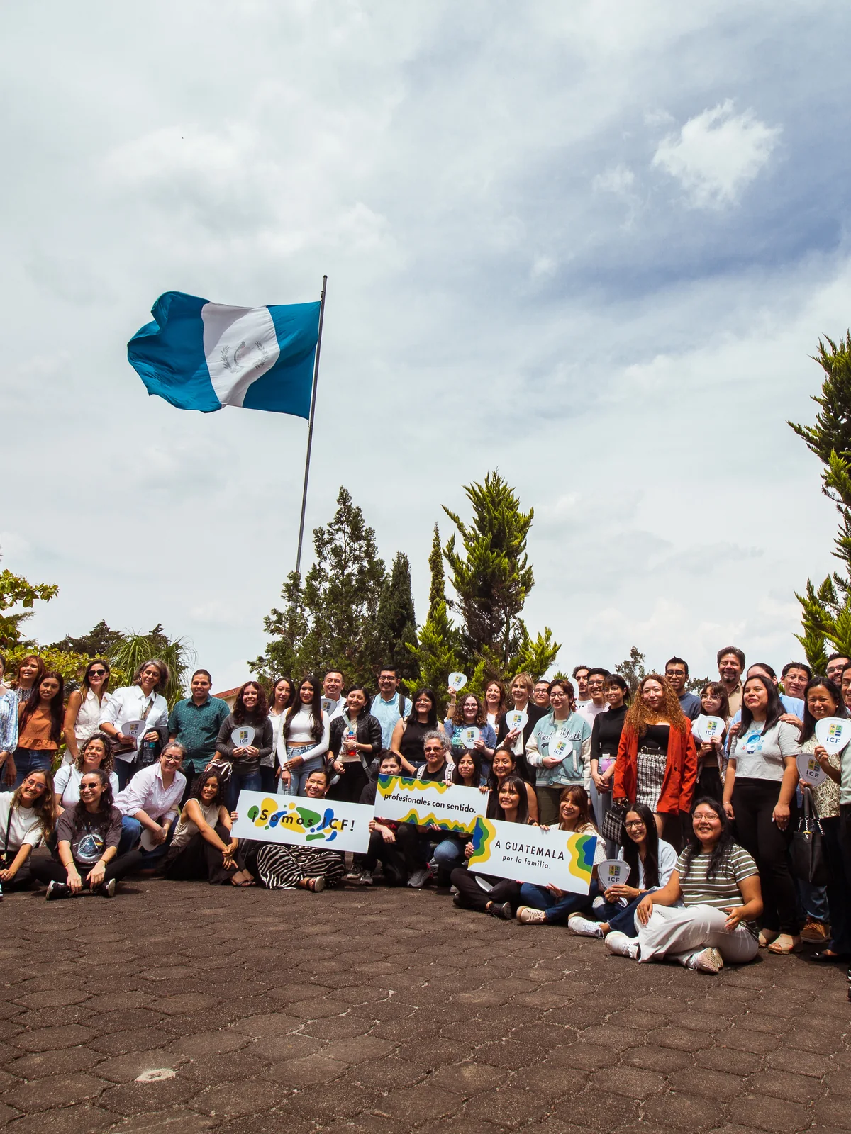Comunidad del ICF reunida frente a la bandera de Guatemala